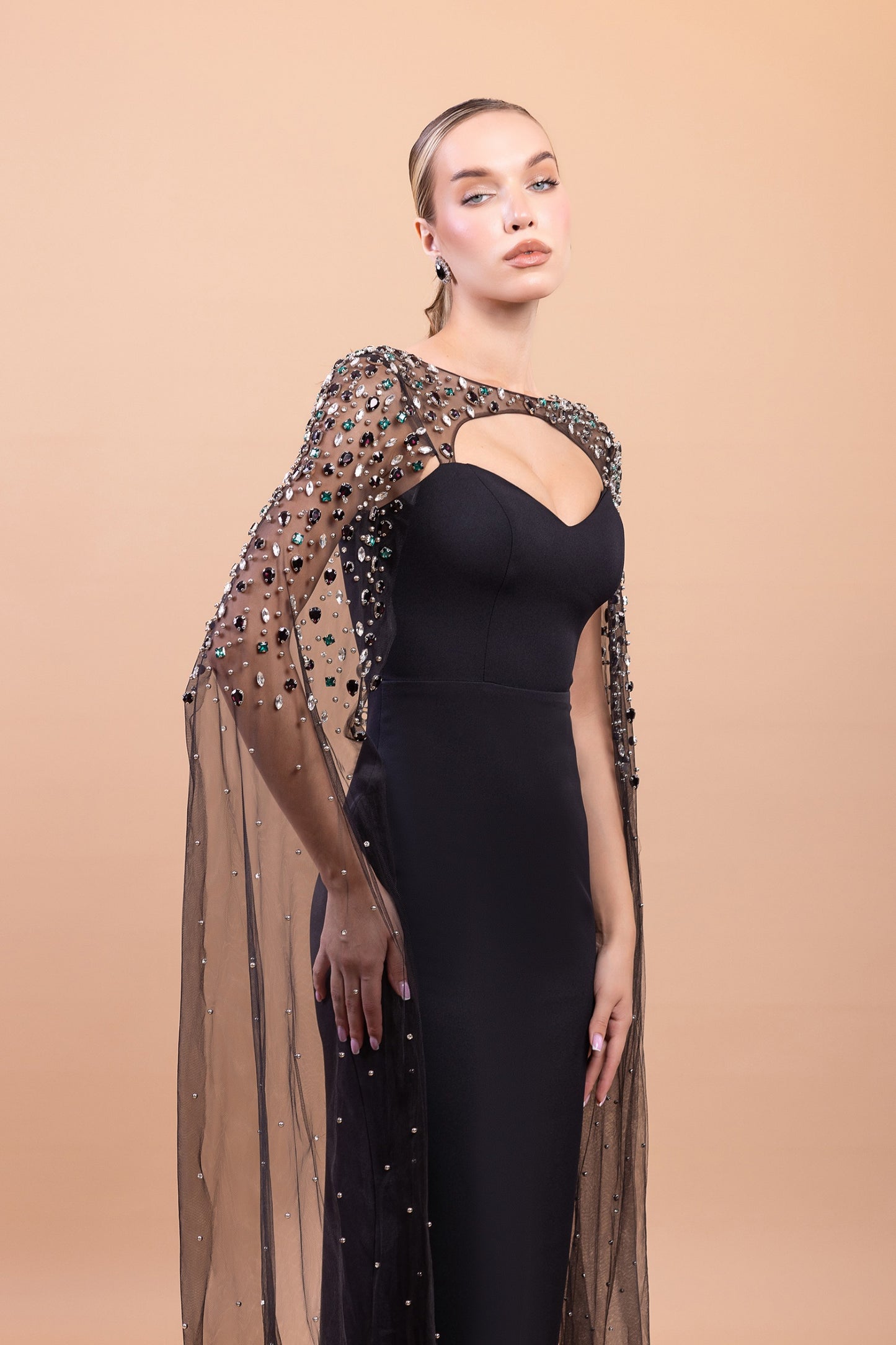 Schwarzes Abendkleid mit glitzernder Cape ist pure Eleganz mit einem Hauch Drama.
Ein Look, den man nie vergisst.